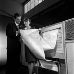 Two programmers read print outs from an English Electric 4554 computer 1966.