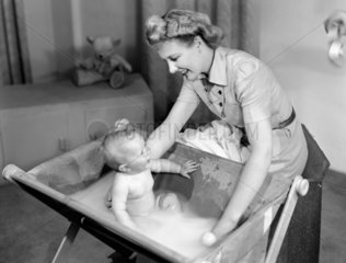 Woman bathing a baby  1948.