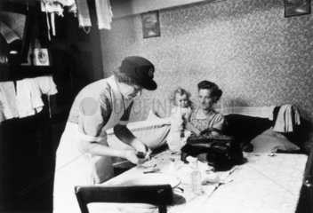 District nurse attending a sick child  November 1955.