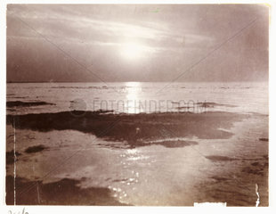 Low sun over a seashore  c 1905.