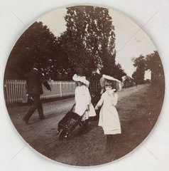 Children walking with a wheelbarrow  c 1890.