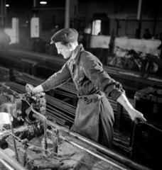 A fitter prepares a machine for draw bar in steel tube production  1948.
