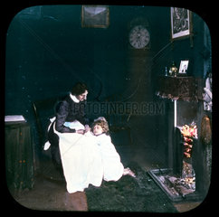 Woman and child in front of fire  c 1895.