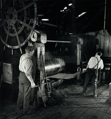 Workers pull steel sheets for tools from rolling machine  Spear and Jackson.