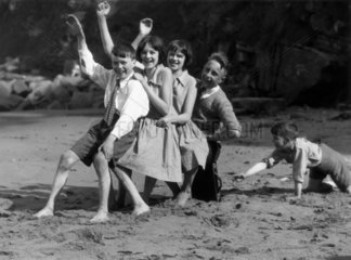 Children playing on a beach  c 1930s.