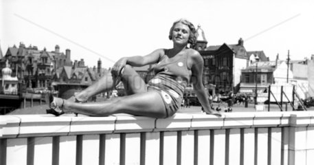 Bathing-suited woman posing for camera  c 1
