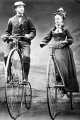 Lady and gentleman riding 'ordinary' bicycles with Starley wheels  1874.