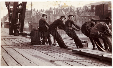 Men pulling a rope  c 1903.