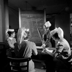 A lesson in the classroom on The Heart with sister and three nurses. 1963.