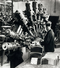 A multiple drill machine in use to test brake linings at Ferodo  1958.