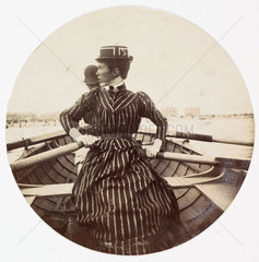 Woman in a rowing boat  c 1890.