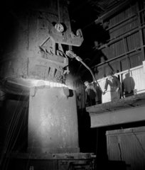 A steel worker adds alloys to open hearth furnace  Consett  1957.