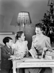 Woman and children wrapping Christmas presents  c 1948.