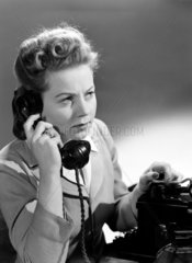 Woman answering telephone  c 1949.