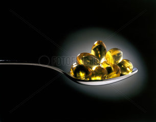 Cod liver oil capsules on a spoon  1998.