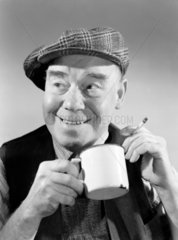 Portrait of a man smoking and drinking from a mug  1949