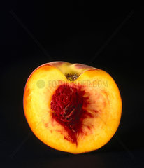 A peach  cut in half to show the stone  1990s.