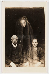 Elderly couple with a young female 'spirit'  c 1920.
