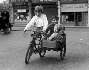 Boys riding on a bicycle with a 'home-made' sidecar  c 1930s.