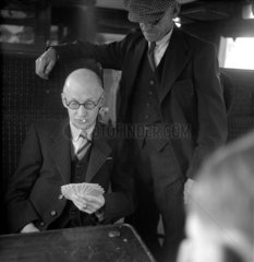 Men playing cards on the train  1950.