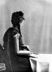 Woman using an artificial arm  1890-1910.