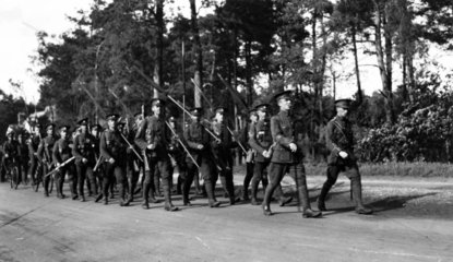 Soldiers marching with rolled-up flags  c W