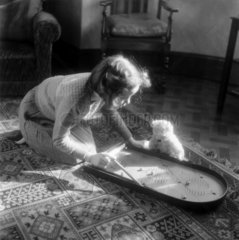 Young girl playing bagatelle  c 1930s.