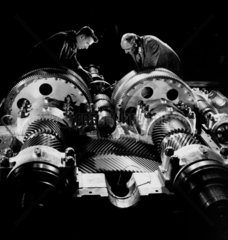 Two engineers inspect cogs of a large frigate gear assembly  1958.