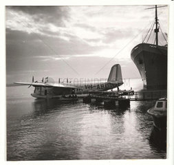 Flying boat moored at a jetty  c 1935.