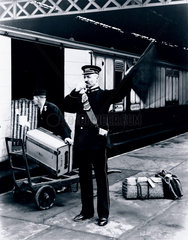 Guard signalling the departure of a LNWR train  London  1907.