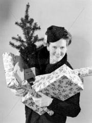 Woman carrying Christmas presents and tree  1947.