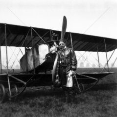 Pilot standing before his aeroplane  c WWI.