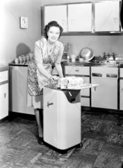 Woman operating a Hoover washing machine and wringer  c 1948.