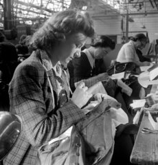 Woman sewing trousers in clothing factory  1948.