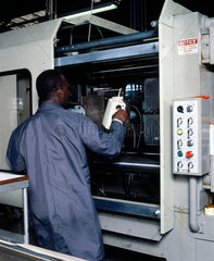 Removing plastic kettle body from an injection moulding machine  c 1985.