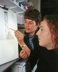 Clinical molecular geneticists studying a radiograph of a DNA sequence  2000.