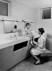 Woman and child in a public lavatory at a Motorail terminal  c 1966.