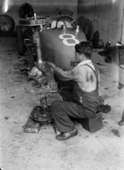 Mechanic working on a Bugatti racing car  Nurburgring  Germany  c 1931.