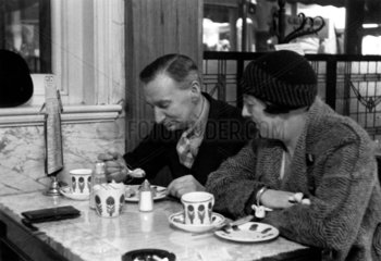 Couple enjoying a snack in a cafe  1930s.