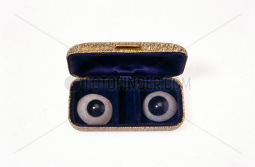 Pair of glass eyes in a case.
