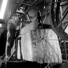 Man uses a wire saw to cut block of granite at Cornish de Lank quarry  1961.