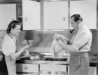 Man and woman working in the kitchen  c 1950.