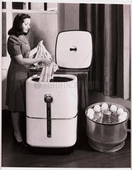 Woman using a Thor washer/dishwashing machine  1947.