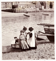 Children playing by the water’s edge  Whitby Harbour  c 1905.