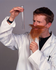 Man with fake beard inspecting a test tube  December 2000.