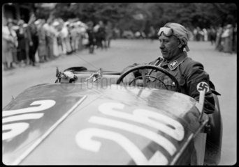 A swastika-wearing driver of a motor racing car  Germany  c 1934.