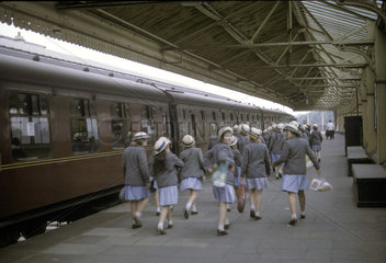 Schoolgirls walking along station platform  Windsor  Berkshire  1966.