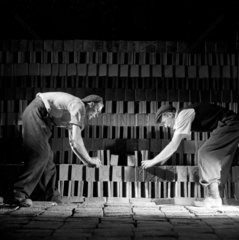 Two kiln workers stack tiles for firing  Wheatley Quarries  1952.