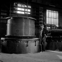 Man with completed drum of cable after winding  Greenwich  1958.
