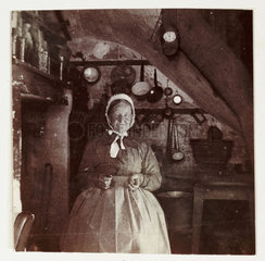 Woman in a kitchen  c 1900.